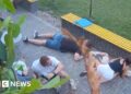 At least six people crouched on the floor as they take shelter from attack neaby