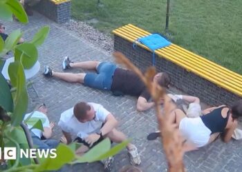 At least six people crouched on the floor as they take shelter from attack neaby