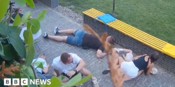 At least six people crouched on the floor as they take shelter from attack neaby