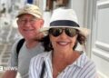 Karen Carter, pictured with her husband Alan. She is wearing dark glasses, a black and white sun hat and a white and striped shirt.