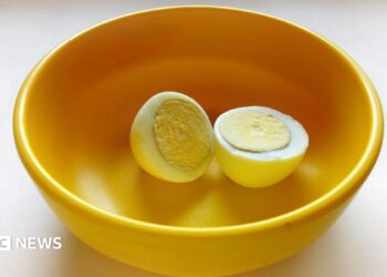 A boiled egg placed in a yellow plastic bowl