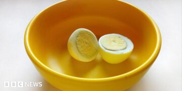 A boiled egg placed in a yellow plastic bowl