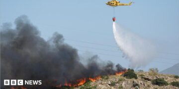 A helicopter works to extinguish flames amid deadly wildfires affecting Almeria province