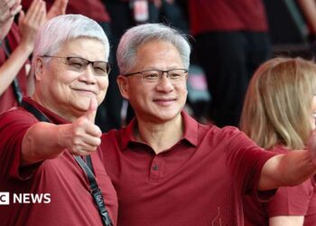 Jensen Huang, chief executive officer of Nvidia (right), poses for photographs with TSMC boss CC Wei smiling with their thumbs up. Both men are dressed in red polo t-shirts