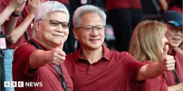 Jensen Huang, chief executive officer of Nvidia (right), poses for photographs with TSMC boss CC Wei smiling with their thumbs up. Both men are dressed in red polo t-shirts