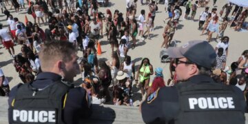 Police overlook a crowd at Orange Crush on Tybee Island on Saturday, April 19.