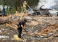 Emergency services clear through the rubble following a Russian missile strike just outside of Kyiv. Firefighters can be seen extinguishing a car fire in the background
