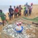 Fisherman on Sherbo Island in Sierra Leone stand around a net holding their latest catch