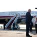 Trump stands in front of Qatari-gifted Air Force One and speaks to reporters who are holding boom microphones