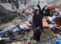 Palestinians inspect the site of Wednesday's Israeli strike on a house whose residents were pre-warned by the Israeli military to evacuate, in Gaza City