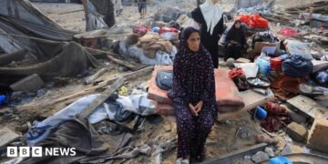 Palestinians inspect the site of Wednesday's Israeli strike on a house whose residents were pre-warned by the Israeli military to evacuate, in Gaza City