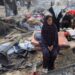 Palestinians inspect the site of Wednesday's Israeli strike on a house whose residents were pre-warned by the Israeli military to evacuate, in Gaza City