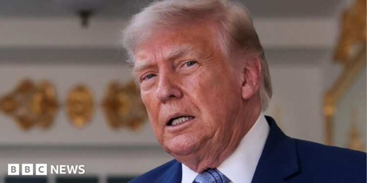 Donald Trump speaking on stage in a tuxedo
