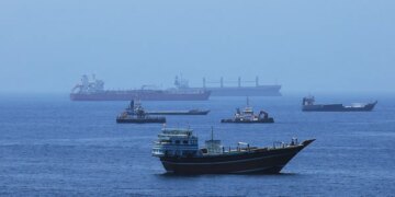 A view of commercial cargo vessels and crude oil tankers are anchored in the Gulf of Oman, off the coast of Muscat, Oman, on June 21, 2026, as they prepare to transit through the critical Strait of Hormuz