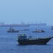 A view of commercial cargo vessels and crude oil tankers are anchored in the Gulf of Oman, off the coast of Muscat, Oman, on June 21, 2026, as they prepare to transit through the critical Strait of Hormuz