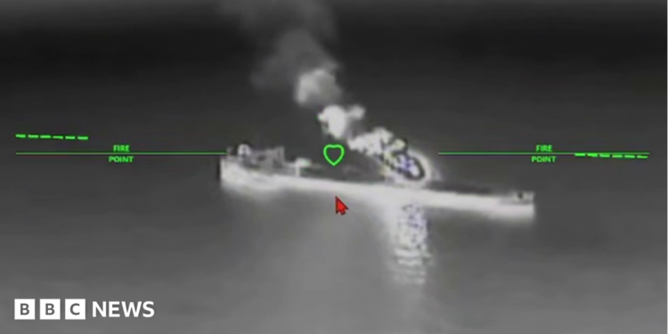 A still image of an oil tanker under attack from a drone in a black and while nighttime image