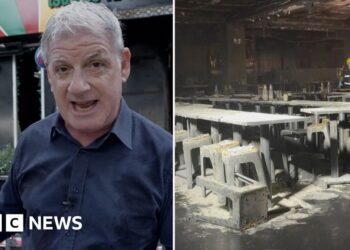 A man speaking in front of a building, and on the right the inside of a burned building with tables and chairs.