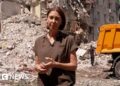 Sarah Rainsford standing in front of rubble