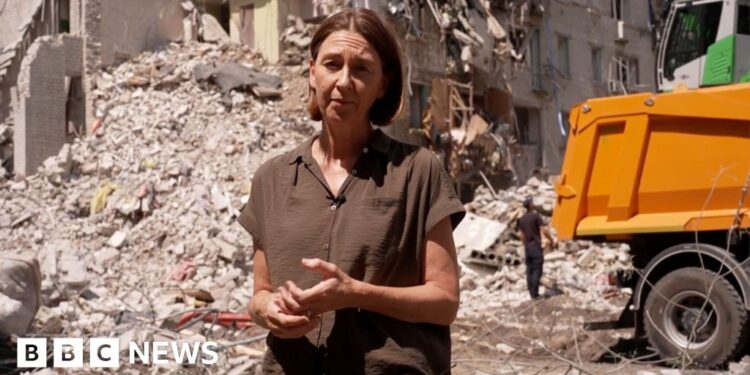 Sarah Rainsford standing in front of rubble