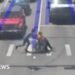 Man dressed as Spider-Man pushes wheelchair user across a crossing