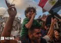 Boy sits on his father's shoulders