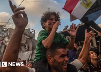 Boy sits on his father's shoulders