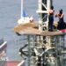 A man and a woman are seen during a proposal on top of the top of the Empire State Building.