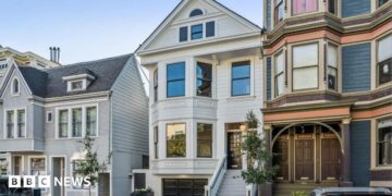 Three homes on a residential street in San Francisco. The three floor homes look clean and well maintained with well-trimmed plants and trees outside.