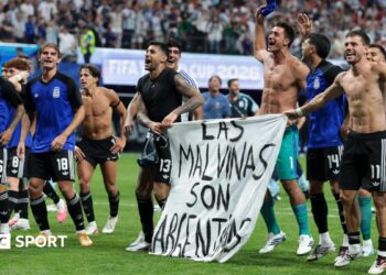 The Argentina players celebrate at full-time with a banner that reads "The Falkland Islands are Argentinian" during the World Cup 2026 semi-final between England and Argentina