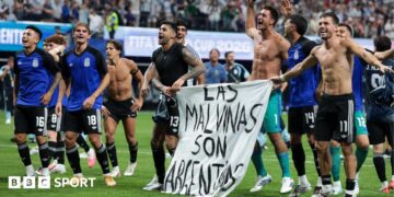 The Argentina players celebrate at full-time with a banner that reads "The Falkland Islands are Argentinian" during the World Cup 2026 semi-final between England and Argentina