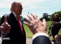 Trump talking to reporters whil holding finger up to camera