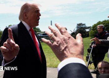 Trump talking to reporters whil holding finger up to camera