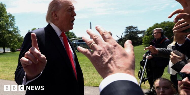 Trump talking to reporters whil holding finger up to camera