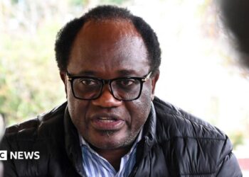 Zambian opposition leader and National Reconciliation Party for Unity Brian Mundubile in a black coat and stripped blue-white shirt