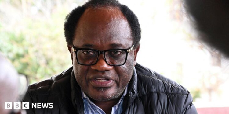 Zambian opposition leader and National Reconciliation Party for Unity Brian Mundubile in a black coat and stripped blue-white shirt