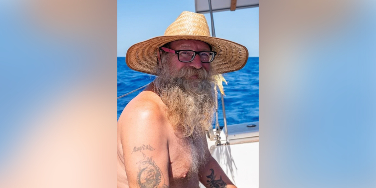 Donald Steven Lang aboard a sailboat wearing a straw hat
