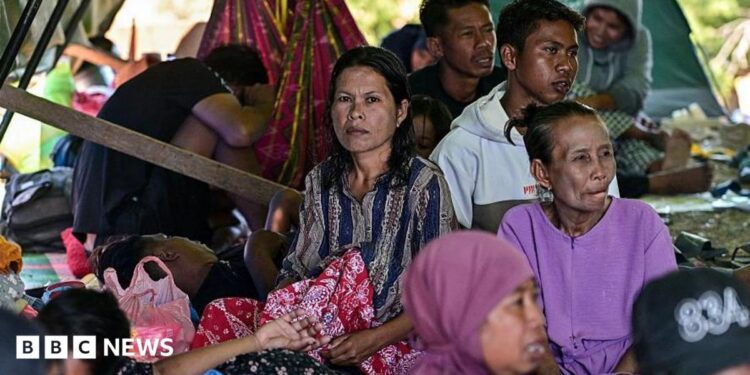 Villagers rest in a tent in an open field in East Nusa Tenggara