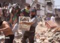 Residents dig through the debris of a collapsed building after an earthquake, in Cali, Colombia