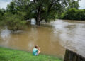 Chace Dexter films the swollen White River due to flooding after days of heavy rain in Noblesville