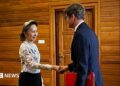 Former Myanmar president Aung San Suu Kyi shakes hands with an official from the International Committee of the Red Cross