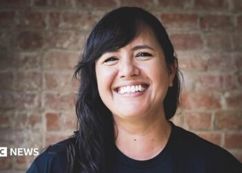 A smiling woman with long black hair.