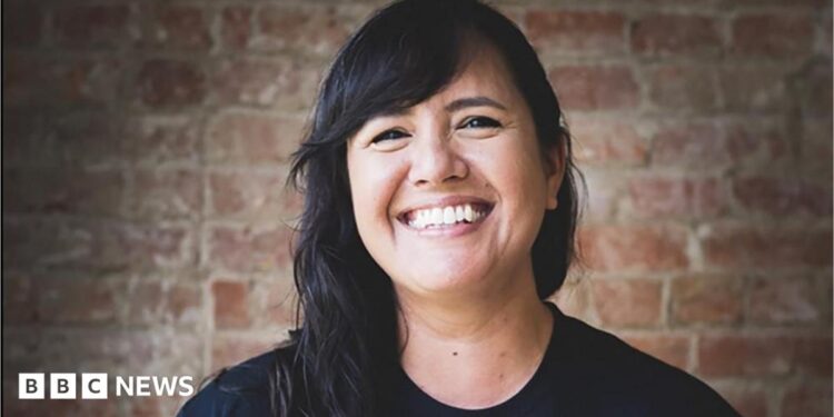A smiling woman with long black hair.