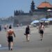 Tourists walk on a beach in Bali