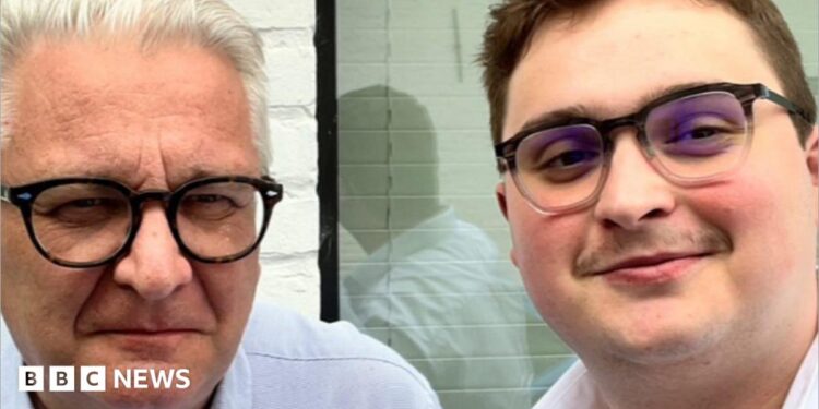 A close-up of two men both wearing glasses