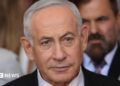 Close up of Benjamin Netanyahu from the shoulders up. He has short, grey hair and is wearing a shirt, tie and suit.
