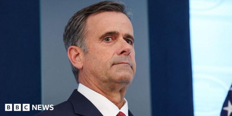 John Ratcliffe seen in a navy suit, with a red tie.