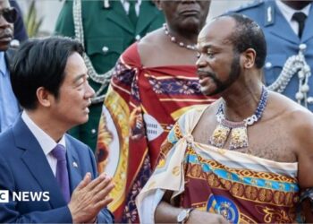 Taiwan's President Lai Ching-te (in navy blue suit white shirt and blue tie) and Eswatini's King Mswati III (in traditional royal regalia) talking