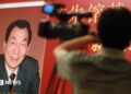 Poster of book with former Chinese premier Zhu Rongji on the cover and a blurred image of a man and a TV camera in the foreground