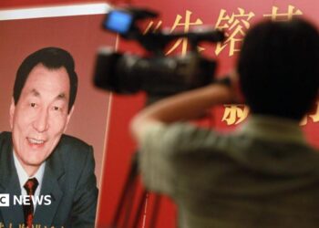 Poster of book with former Chinese premier Zhu Rongji on the cover and a blurred image of a man and a TV camera in the foreground