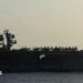 Side view of USS Abraham Lincoln as a small jet lands on it